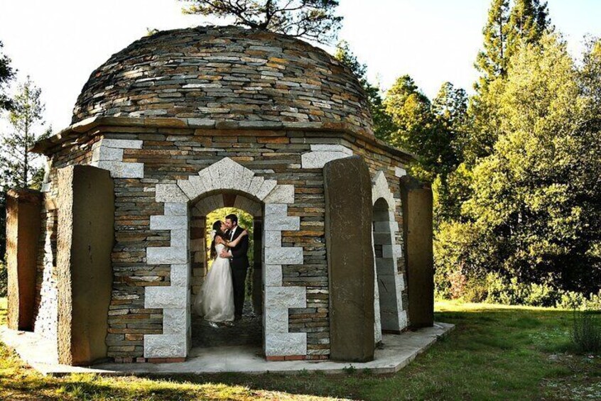 A stone gazebo with a dome roof and an arched entrance. 4