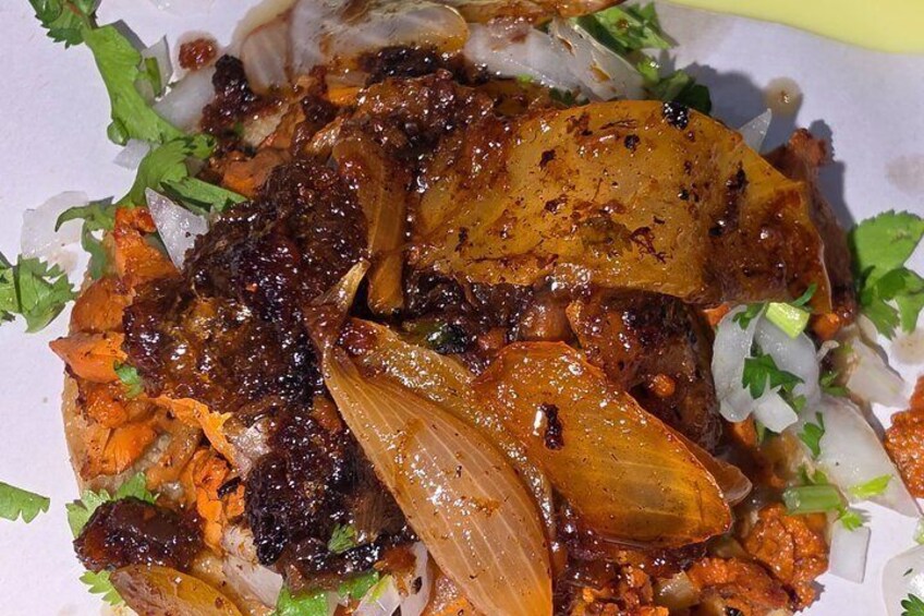 A dish with meat, onions, and herbs. 5