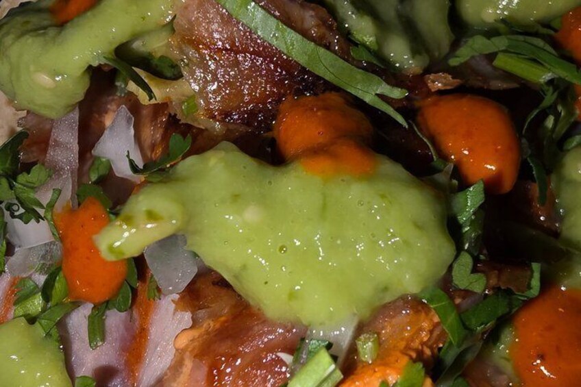 A close-up of a dish with various vegetables and a green sauce. 3