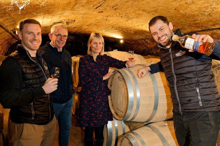 People in a cellar with wine barrels. 1