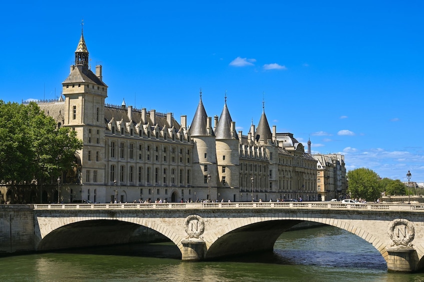 A historic building with multiple towers and a bridge over a river. 1