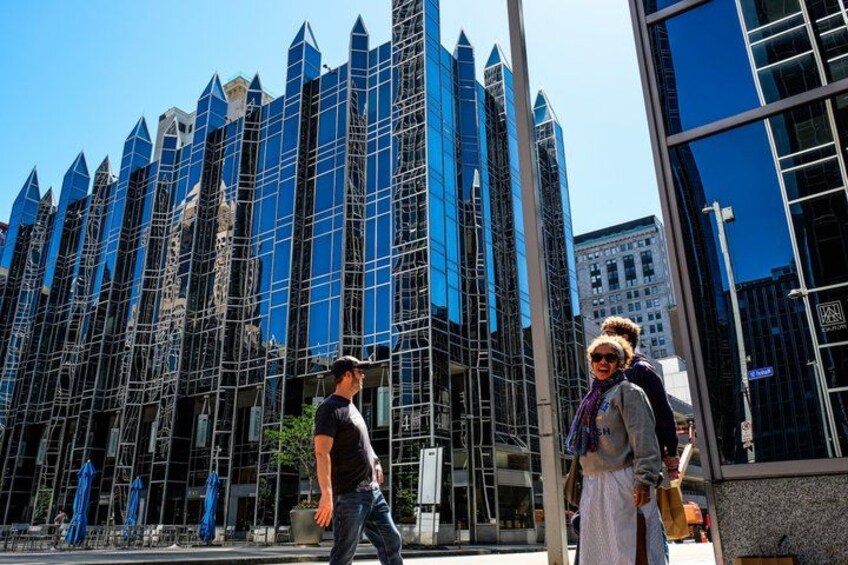 A modern building with a reflective glass facade and a series of pointed structures. 3