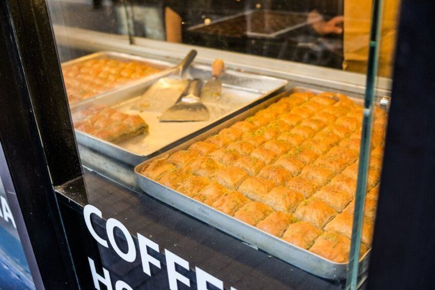 A display case with trays of baked goods, possibly pastries, in a bakery or cafe. 2