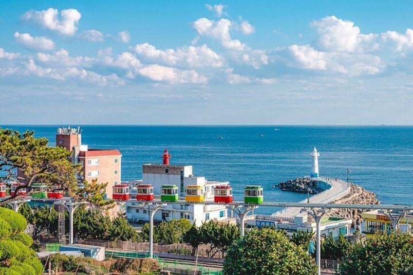 A coastal town with colorful buildings, a lighthouse, and a pier extending into the sea. 5