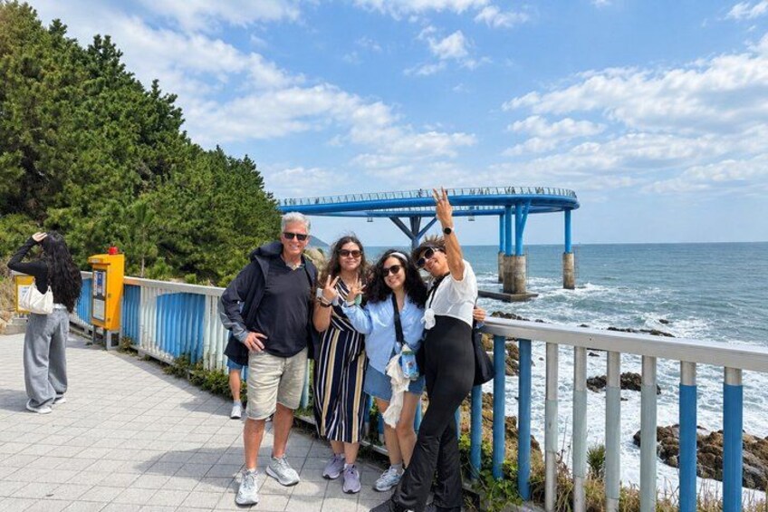 A group of people standing on a pier with a bridge in the background. 4