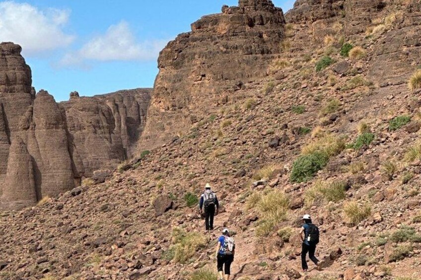 Hikers on a rocky trail with a mountainous landscape in the background. 4