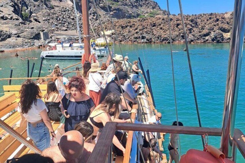 A group of people on a boat near rocky shores. 5