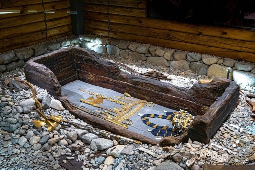 A wooden coffin with gold jewelry on a stone floor. 2