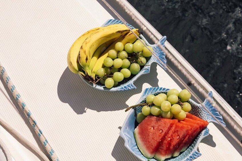 Un bateau contenant deux bols de fruits, l’un rempli de bananes et de raisins, l’autre de pastèque. 5