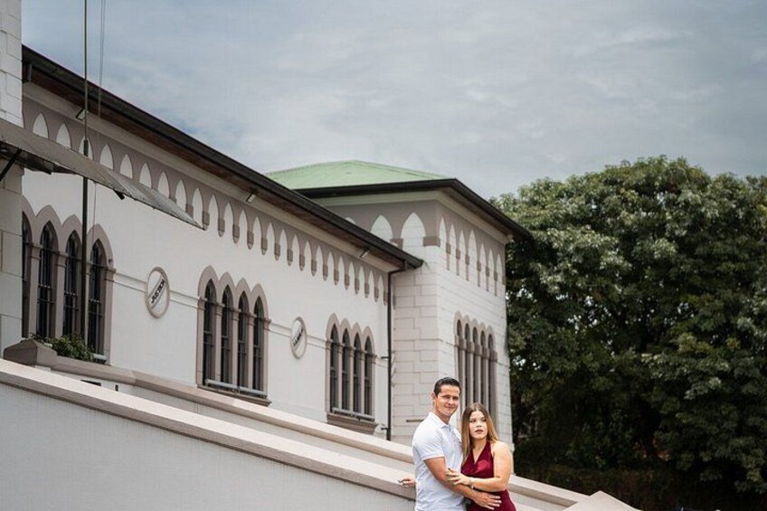 A couple standing in front of a building with arched windows and a green roof. 3