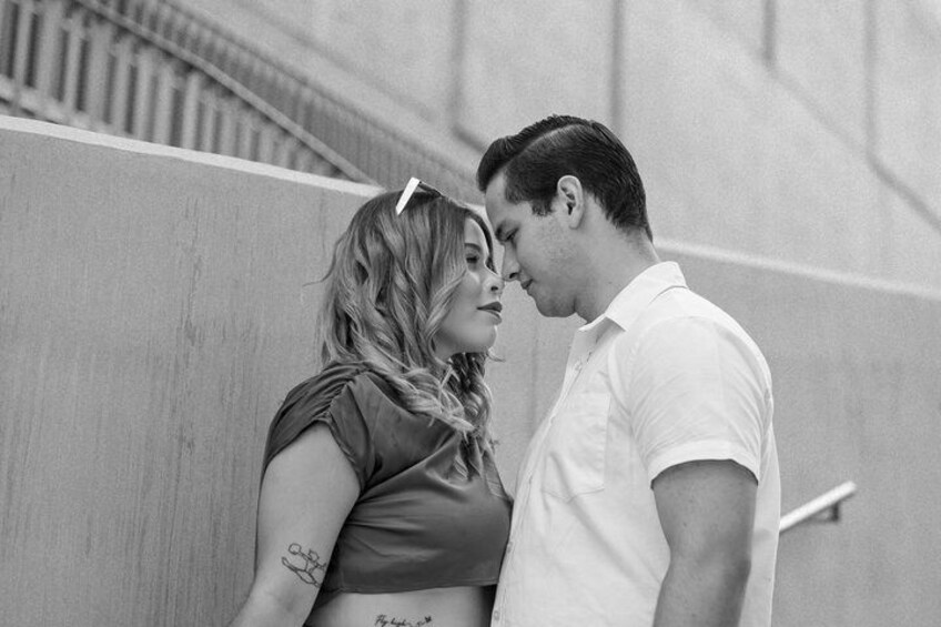 A couple standing close together, a woman with a tattoo on her arm, and a man in a white shirt. 4