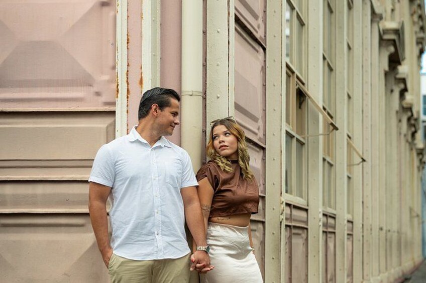A man and a woman standing in front of a building with large windows and a beige facade. 4