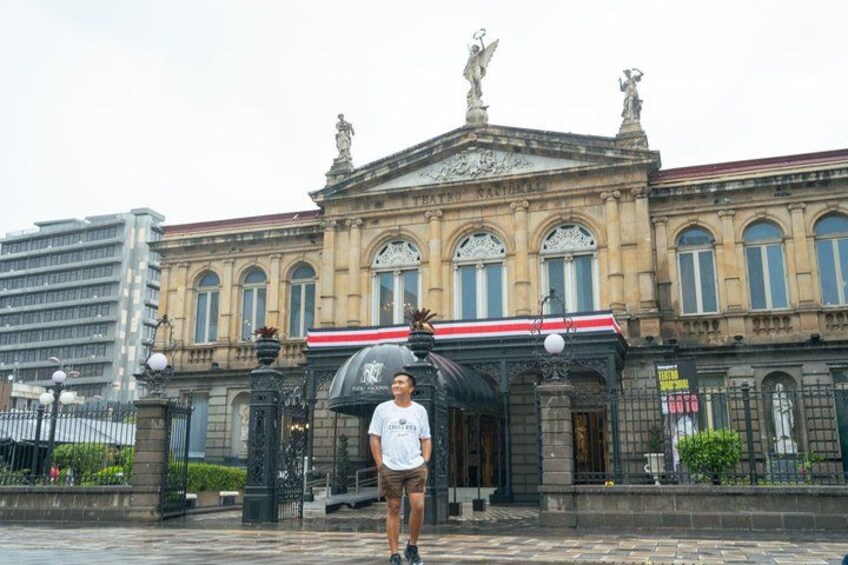 A person standing in front of a historic building with ornate architecture and statues. 4