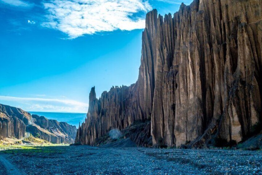 A rugged cliff with vertical rock formations and a clear sky. 2