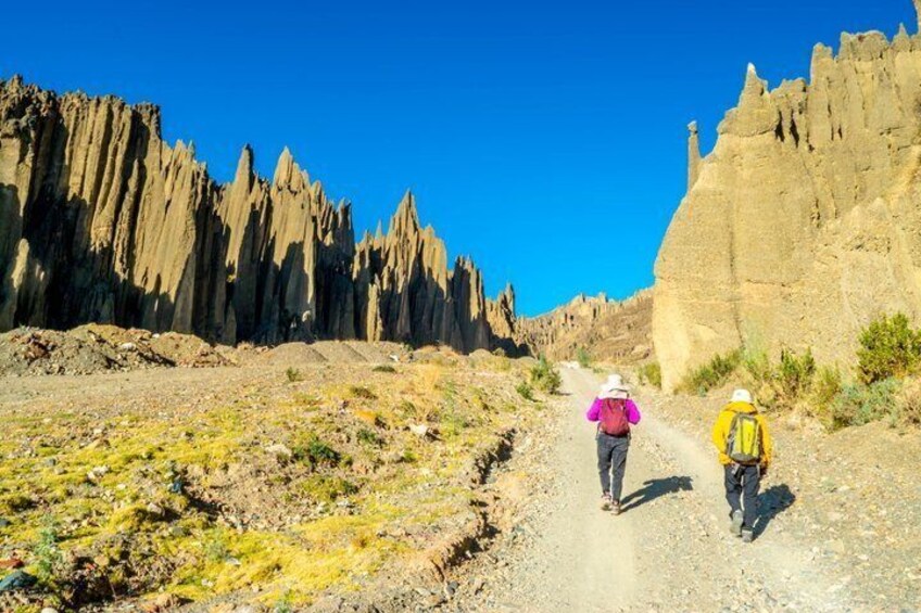 Two hikers on a rocky trail with steep cliffs on either side. 5