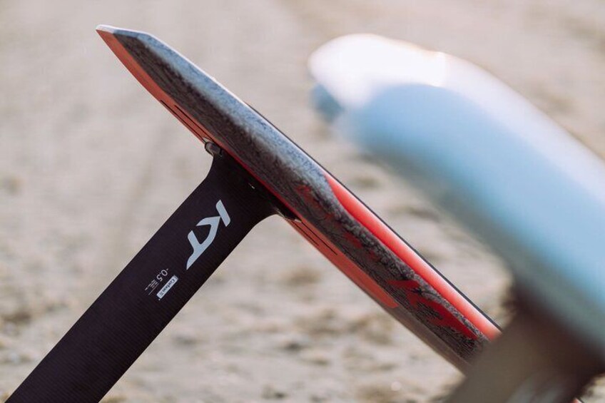 A close-up of a skateboard with a black and red design, featuring a logo and text on the underside. 3