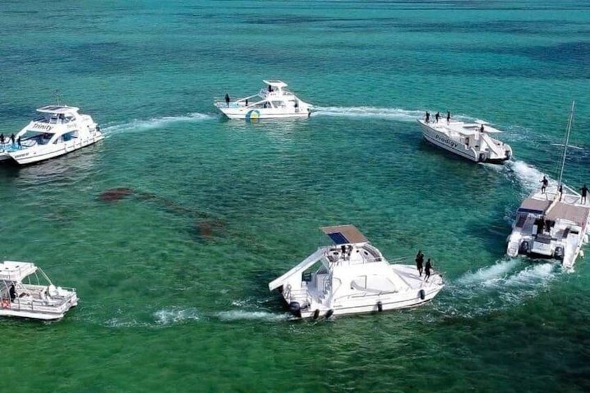A group of boats anchored in clear turquoise water. 4