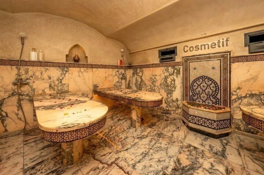 A bathroom with marble floors and walls, multiple sinks, and a decorative wall panel labeled 'Cosmetif'. 4