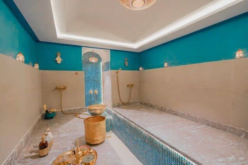 A bathroom with a blue mosaic wall, a bathtub, and a shower area. 3