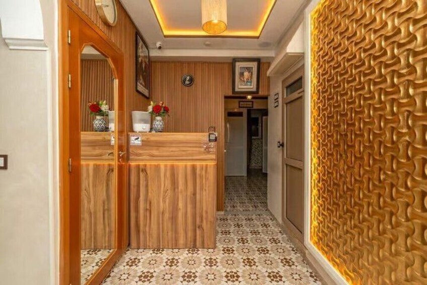A reception desk with a wooden finish, a patterned floor, and a textured wall. 5