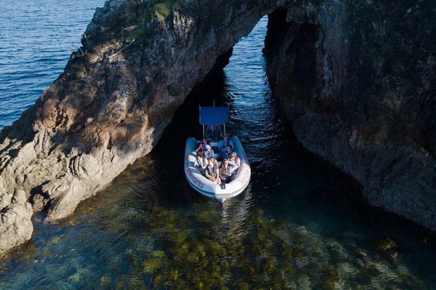 A boat navigating through a natural rock arch formation. 2