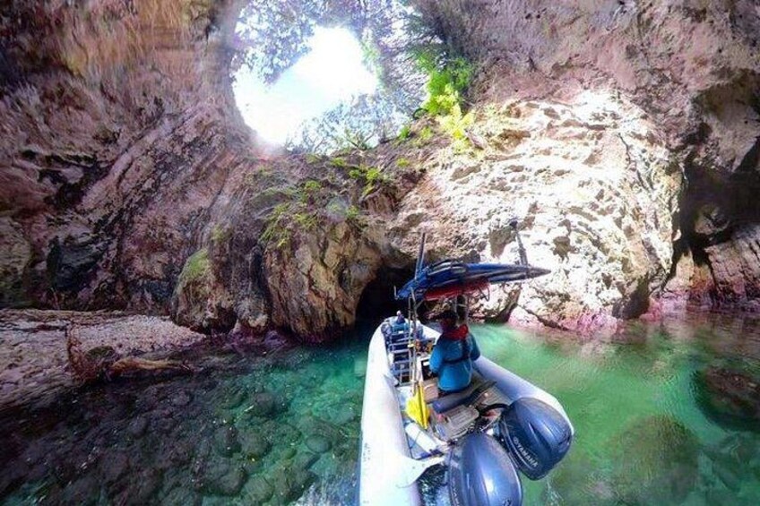 Una canoa deslizándose por una cueva rocosa con aguas transparentes. 1