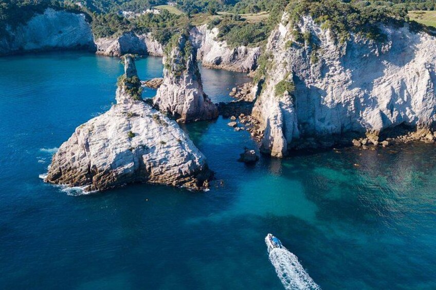 A coastal landscape with rocky formations and clear blue waters. 2