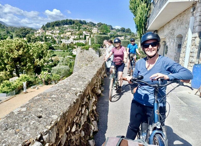 Cyclists on a stone pathway with a view of a town and hills in the background. 3