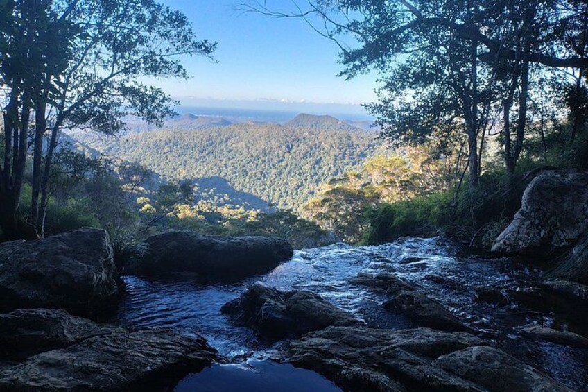 A river flowing through a mountainous landscape with dense forest on either side. 5