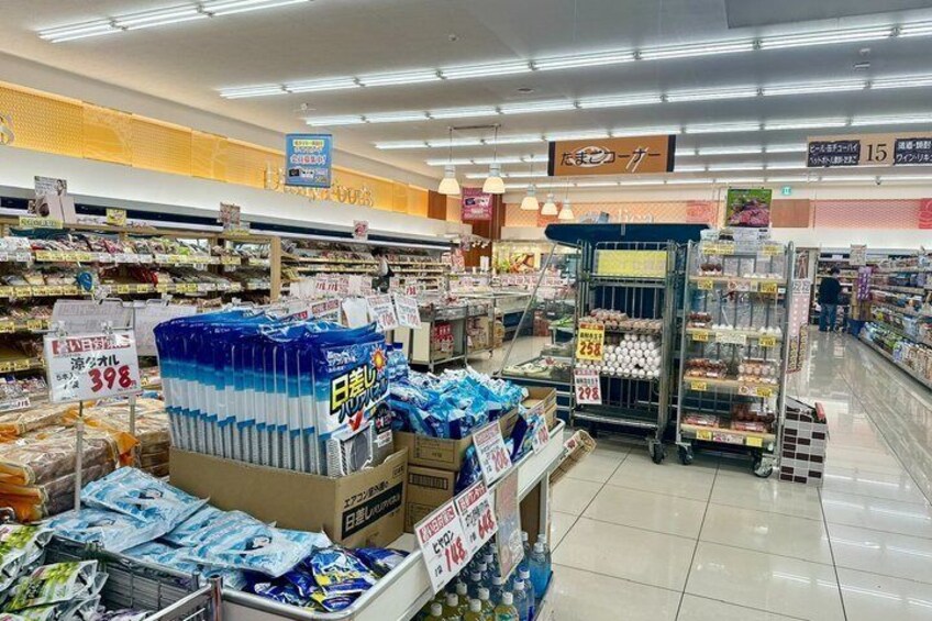 A supermarket aisle with packaged goods and price tags. 2