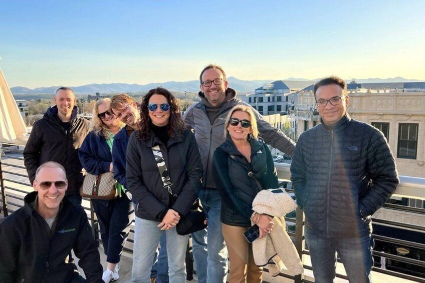 A group of people on a rooftop with a cityscape in the background. 3