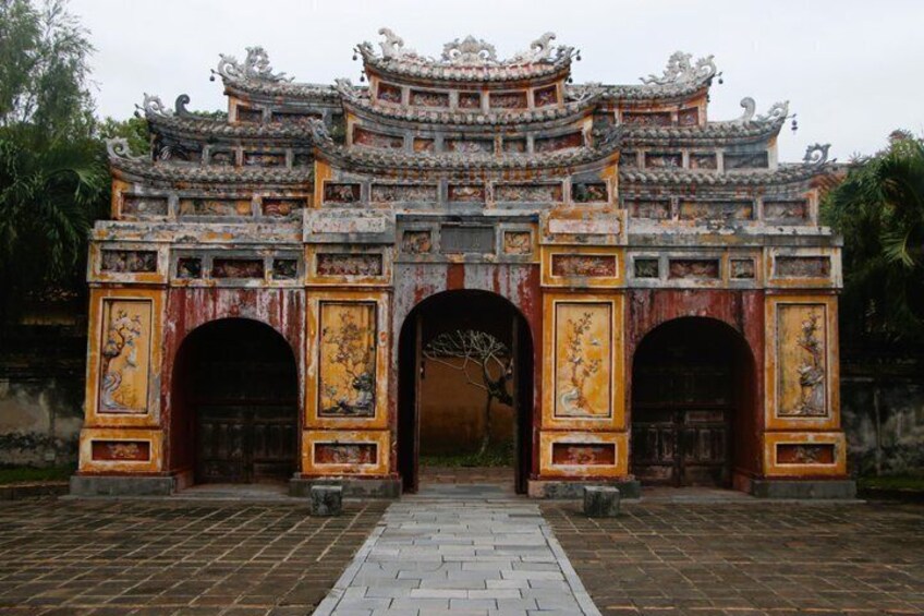 A traditional gate with ornate carvings and a tiled roof. 4