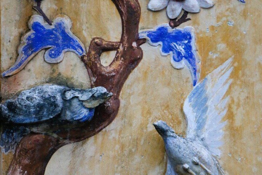 A wall with a bird and branch mural. 3