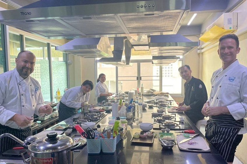 A professional kitchen with chefs preparing food. 1