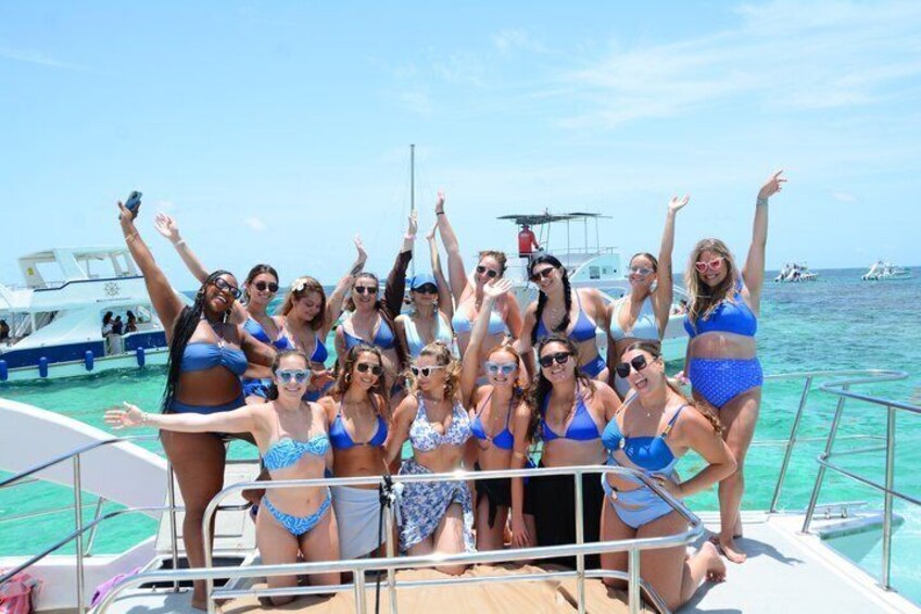 A group of people on a boat with the ocean and other boats in the background. 2