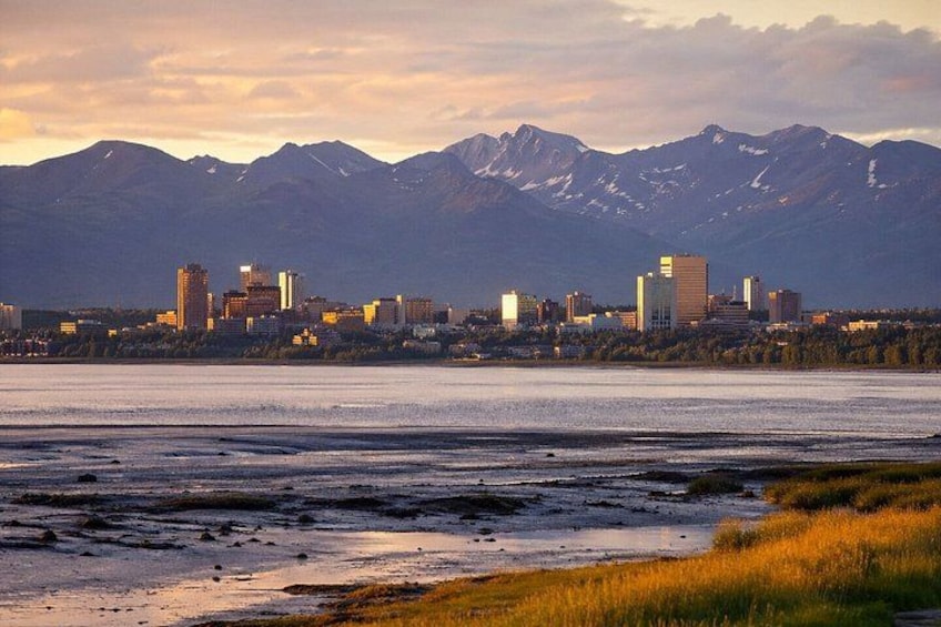 A city skyline with mountains in the background. 1