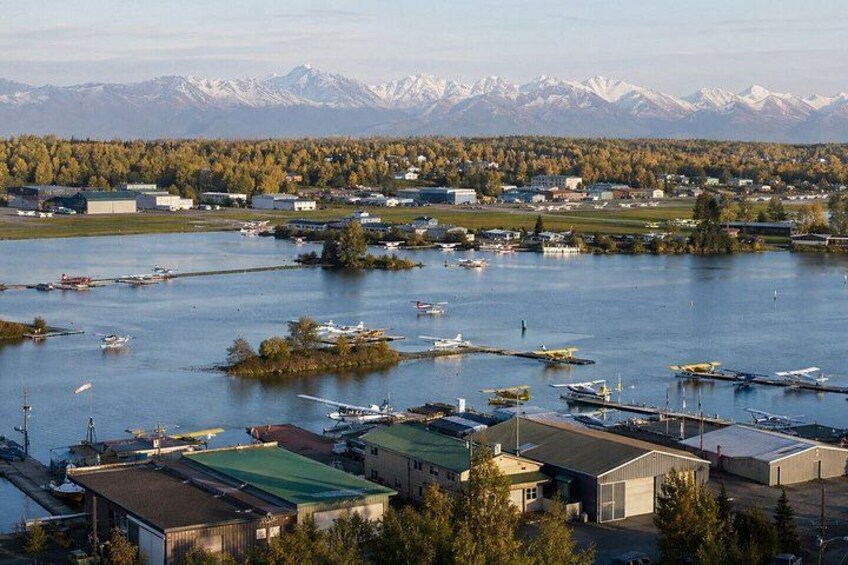A marina with boats, a small island, and a mountainous backdrop. 2
