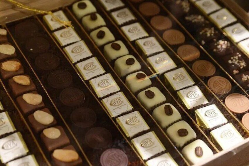 A variety of chocolates in a box, some with nuts and others with different fillings. 3