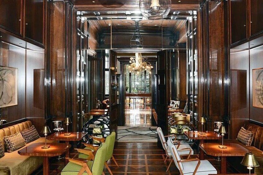 A luxurious interior with wooden paneling, leather seating, and a chandelier. 2