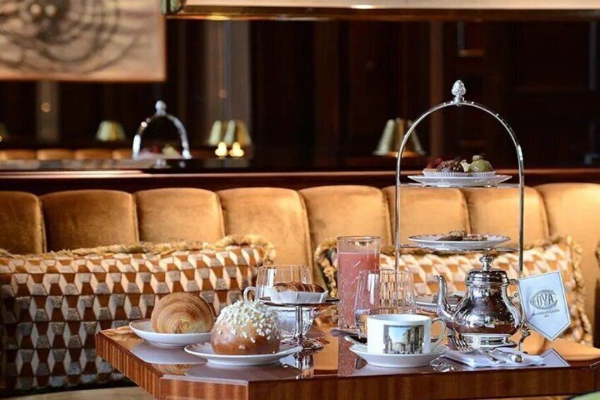 A table set with pastries, a teapot, and a tray with fruits and sandwiches. 4
