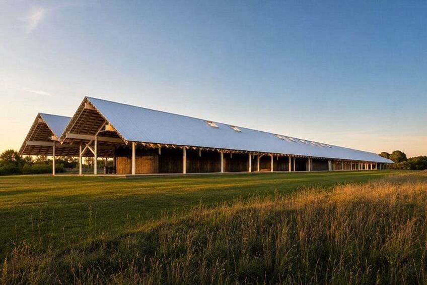 A large, modern barn with a flat roof and multiple covered sections. 3