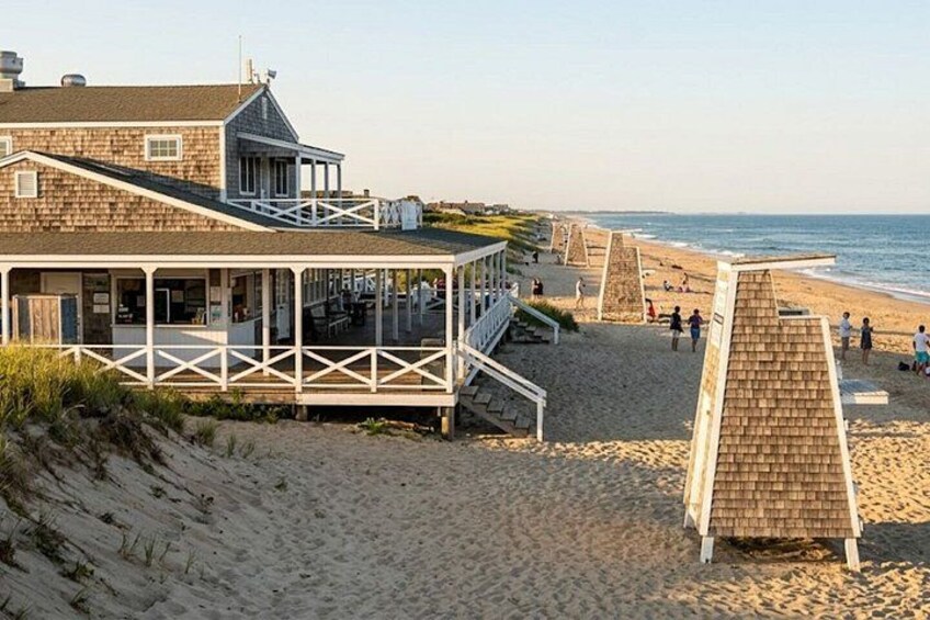 A beach with a wooden structure, a staircase, and people walking. 2