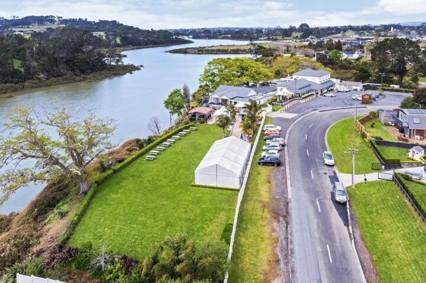 A riverside road with a curve, a grassy area, and buildings in the background. 4