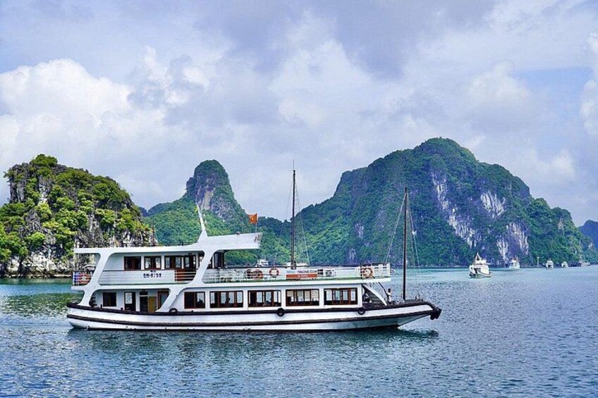 A boat on calm water with a mountainous backdrop. 1