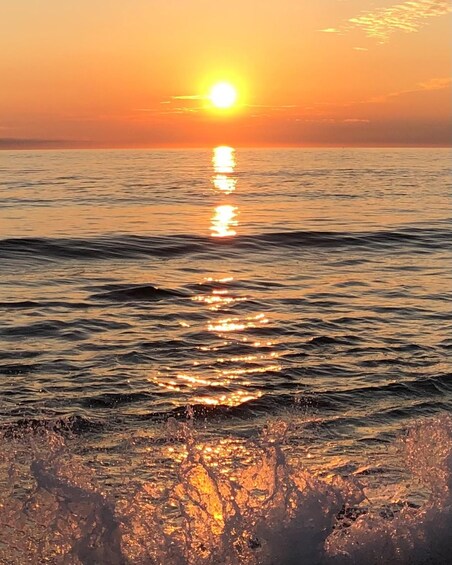 A sunset over a calm sea with sunlight reflecting on the water. 2