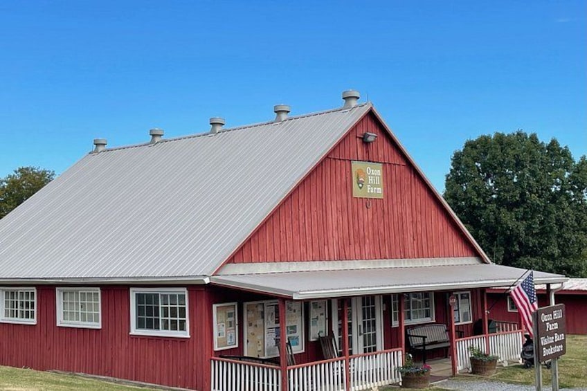A red barn with a white porch and an American flag. 3