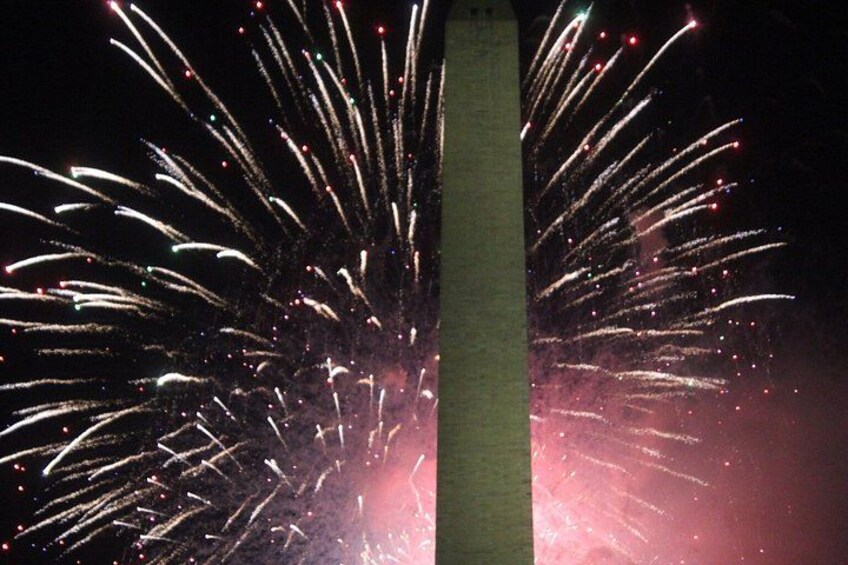 Fuochi d'artificio che esplodono nel cielo con un imponente monumento sullo sfondo. 2