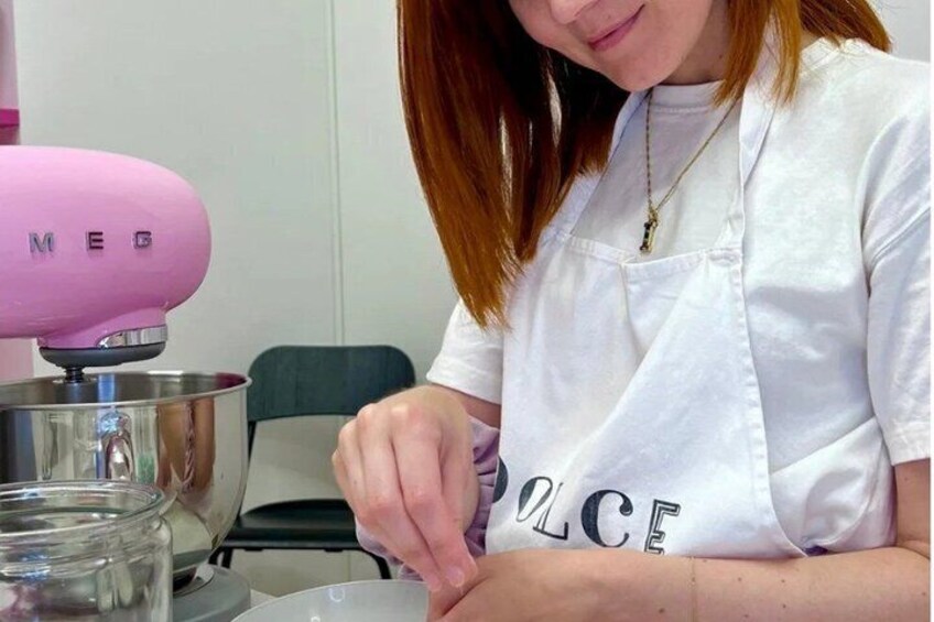 A person wearing a white shirt with 'POLICE' text, using a pink mixer. 2