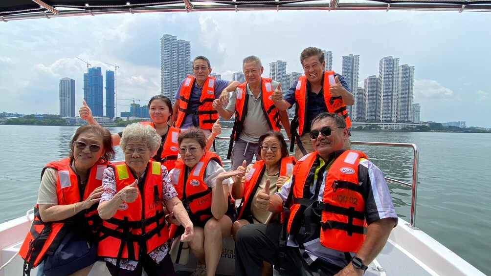 A group of people on a boat wearing life jackets, with a city skyline in the background. 5