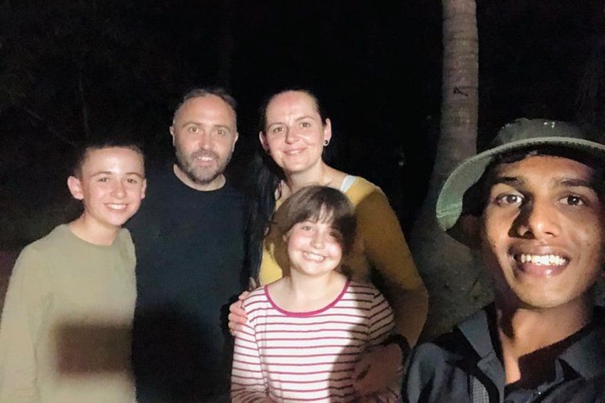 A group of people standing outdoors at night. 3